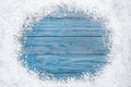 Frame of white snow on blue wooden , top view with space for text. Christmas season Royalty Free Stock Photo