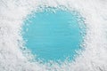 Frame of white snow on light blue wooden background, top view. Christmas season Royalty Free Stock Photo