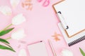 Frame of white tulips flowers, clipboard, clips and scissors on pink background. Blogger concept. Flat lay, top view. Royalty Free Stock Photo