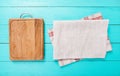 Frame of food wooden cutting board and kitchen tablecloth on blue table. Top view and copy space. Place for your text. Mock up Royalty Free Stock Photo