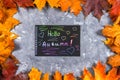 A frame of yellow and orange autumn maple leaves on gray dark concrete. Black plate with colored text. The inscription is hello au Royalty Free Stock Photo