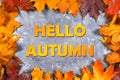 A frame of yellow and orange autumn maple leaves on gray dark concrete. The inscription is hello autumn. Royalty Free Stock Photo