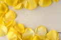 Frame of yellow rose petals on a wood background. Royalty Free Stock Photo