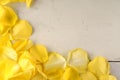 Frame of yellow rose petals on a wood background. Royalty Free Stock Photo