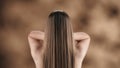 In the frame, a young woman with long, straight, blonde hair stands against a blotchy background. She stands with her Royalty Free Stock Photo