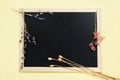 Framed blackboard decorated with beautiful blossom branch over yellow background. Copy space Royalty Free Stock Photo