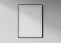 Framed blank canvas against a light grey wall. The frame is black, Royalty Free Stock Photo