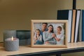 Framed family photo on wooden shelf