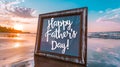 A framed Happy Fathers Day! message sits on a tranquil beach at sunset, evoking peaceful reflections Royalty Free Stock Photo