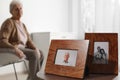 Framed photos and blurred female pensioner on background