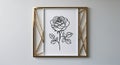 A framed rose line art print with a gold geometric frame hanging on a white wall space Royalty Free Stock Photo