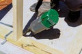Framer worker installing beams using air nails hammer in a nailing wooden frame Royalty Free Stock Photo