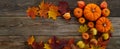 Framework with pumpkins and fall leaves on wooden background. Top view. Royalty Free Stock Photo