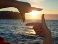 Framing sun above sea. Hands making frame Royalty Free Stock Photo