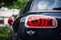 France Beaune 2019-06-19 Closeup red headlight of new dark blue shiny car Mini Cooper parking on the street. Back view Royalty Free Stock Photo