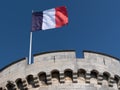France flag waving against clean blue sky at La Rochelle Tower