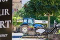 France, 1, July, 2024: Blue tractor and bicycle in a small village