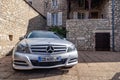 France Lyon 2019-06-20 closeup luxury silver German car sedan premium Mercedes C class with EU registration number near stone