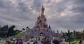 France, Paris, 20 June 2023: Pink fairytale castle in Disneyland. Disneyland amusement park complex in Paris. Crowd of