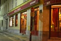 Very cute, colorful and pink cafe facade in Paris Street during night.