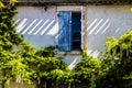 France, Provence. Typical old house, open window with the blue shutters surrounded a green plants