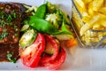 Franch meal with tomato and beans salad, french fries and steak with souse