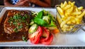 Franch meal with tomato and beans salad, french fries and steak with souse