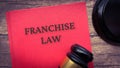 Franchise law book and gavel on wooden table. Royalty Free Stock Photo