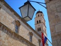 Franciscan monastery in Dubrovnik. View of the tower and dome. The Croatian flag is erected on the wall of the building. Street Royalty Free Stock Photo