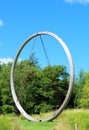 FRANCONIA SCULPTURE PARK, SHAFER, MINNESOTA Wooden circle statue in a blue sky with clouds and green field