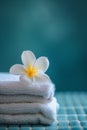 Frangipani flower on stack of white towels, a close-up of a delicate, pink plumeria flower with soft petals, on a white Royalty Free Stock Photo