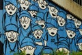 Graffito of a flock of sheep in blue clothing.