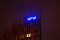 Illuminated logo at the KfW headquarters in Frankfurt at night.