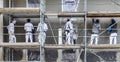 Painter and plasterer work on a scaffold to renovate an old wall