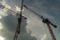 Silhouette of several construction cranes against a turbulent sky. Royalty Free Stock Photo