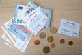 Frankfurt - June 2022: 9-euro travel subscription lie on table among euro coins, monthly travel passes in germany for public