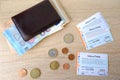 Frankfurt - June 2022: 9-euro travel subscription lie on table among euro coins, monthly travel passes in germany for public