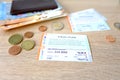 Frankfurt - June 2022: 9-euro travel subscription lie on table among euro coins, monthly travel passes in germany for public