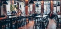 Frankfurt am Main, Germany - Juni 11, 2019: Interior of cozy German cafe with high tables and chairs and happy people in the backg