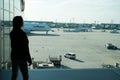 Frankfurt am Main, Germany - October 11, 2015: woman in airport. Girl silhouette look at planes on airdrome ground on sunny day. T Royalty Free Stock Photo