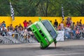 FRANKFURT AM MAIN, GERMANY - SEPT 2022: green BMW 325i E36 car rides sideways on two wheels, at an auto show, Monster Truck auto