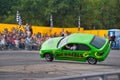 FRANKFURT AM MAIN, GERMANY - SEPT 2022: green BMW 325i E36 car rides sideways on two wheels, at an auto show, Monster Truck auto