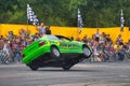 FRANKFURT AM MAIN, GERMANY - SEPT 2022: green BMW 325i E36 car rides sideways on two wheels, at an auto show, Monster Truck auto