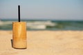 Frappe, ice coffee on the beach. Summer iced coffee (frappuccino, frappe or latte) in a tall glass