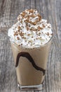 Frappuccino with ice in take away cup, with straws and grains of coffee on a wooden table, copy space Royalty Free Stock Photo