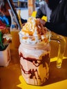 Frappuccino in large glass mug on the table at cafe in a sunny day