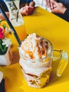 Frappuccino in large glass mug on the table at cafe in a sunny day