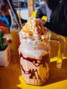 Frappuccino in large glass mug on the table at cafe in a sunny day.