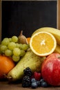 Frash Fruit, Orange, apple, banana, pear, grapes against blackboard