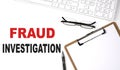 Fraud Investigation text written on the white background with keyboard, paper sheet and pen